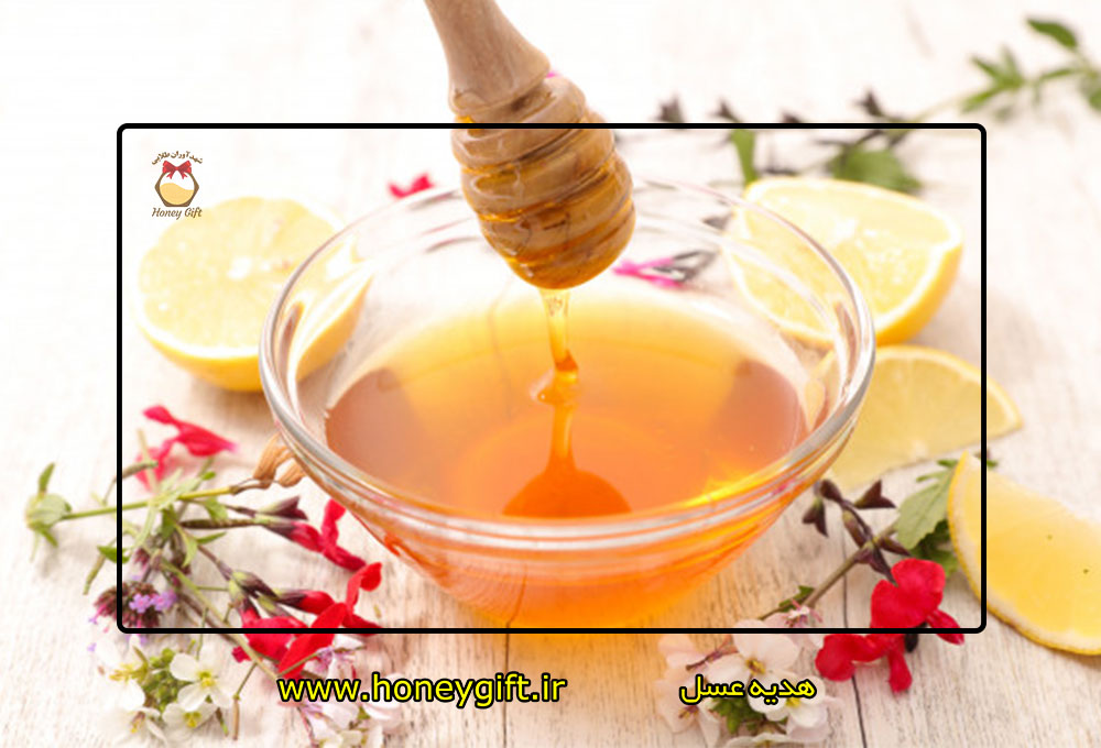 قاشق عسل در بالای ظرف در کنار برش لیمو ترش
