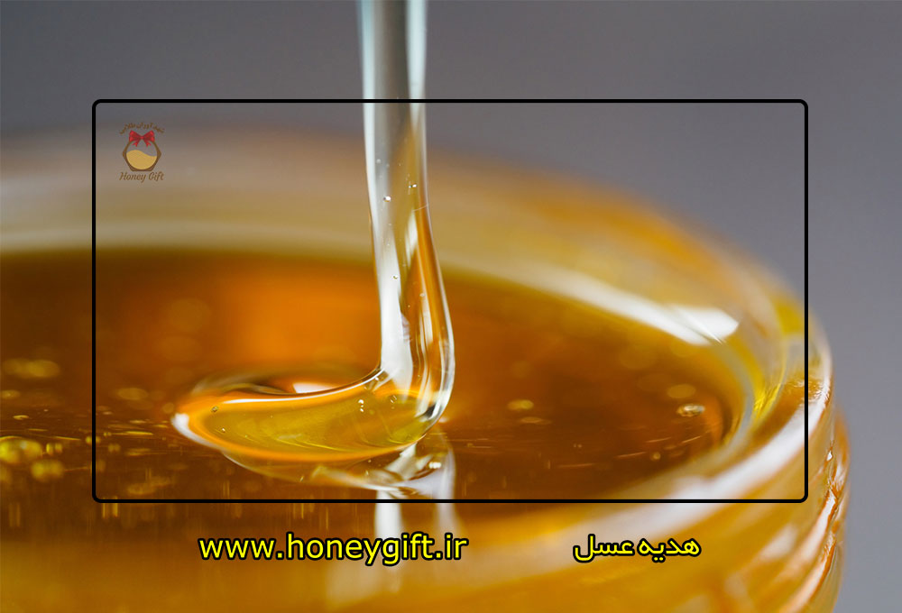 نمایی از ریختن عسل داخل ظرف شیشه ای عسل